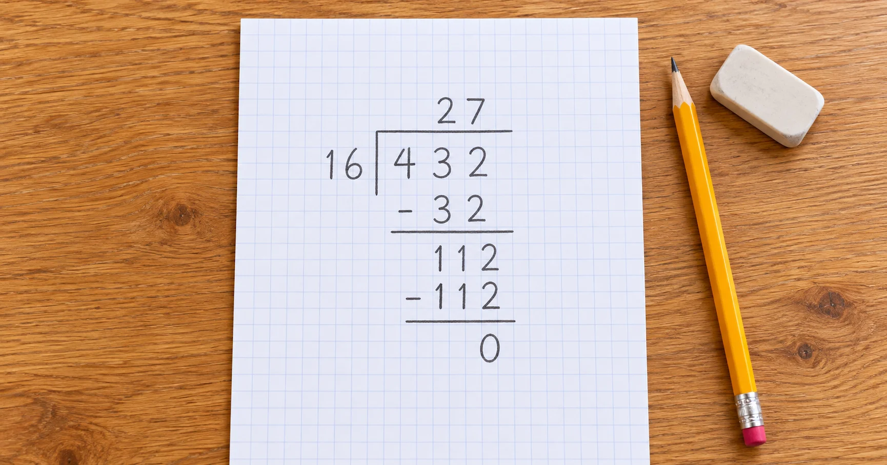 Overhead shot of a handwritten long division calculation using the bus stop method on squared exercise paper, showing 432 divided by 16 equals 27